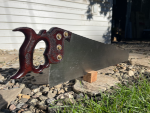 Picture of a Dennis Wayne panel saw with a rosewood wheat carved handle