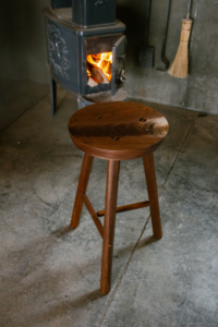 Hand made wooden stool in front of a fireplace
