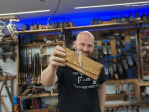 Photo of James Wright holding a wooden Grooving plane